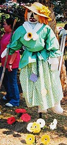 A scarecrow decorated with flowers